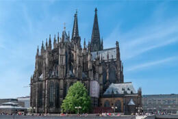 Cologne's multi-spired gothic cathedral stands out darkly against a blue sky