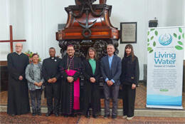 Ecumenical clergy line up in front of an ornately carved wooden pulpit