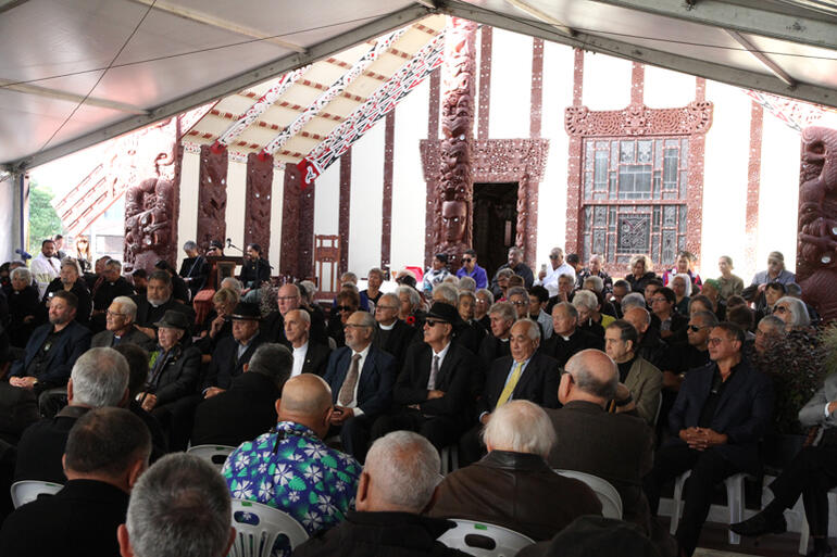 Local people sit before Tama-te-Kapua wharenui at Papaiouru Marae to hear the stories and reflections from manuhiri.